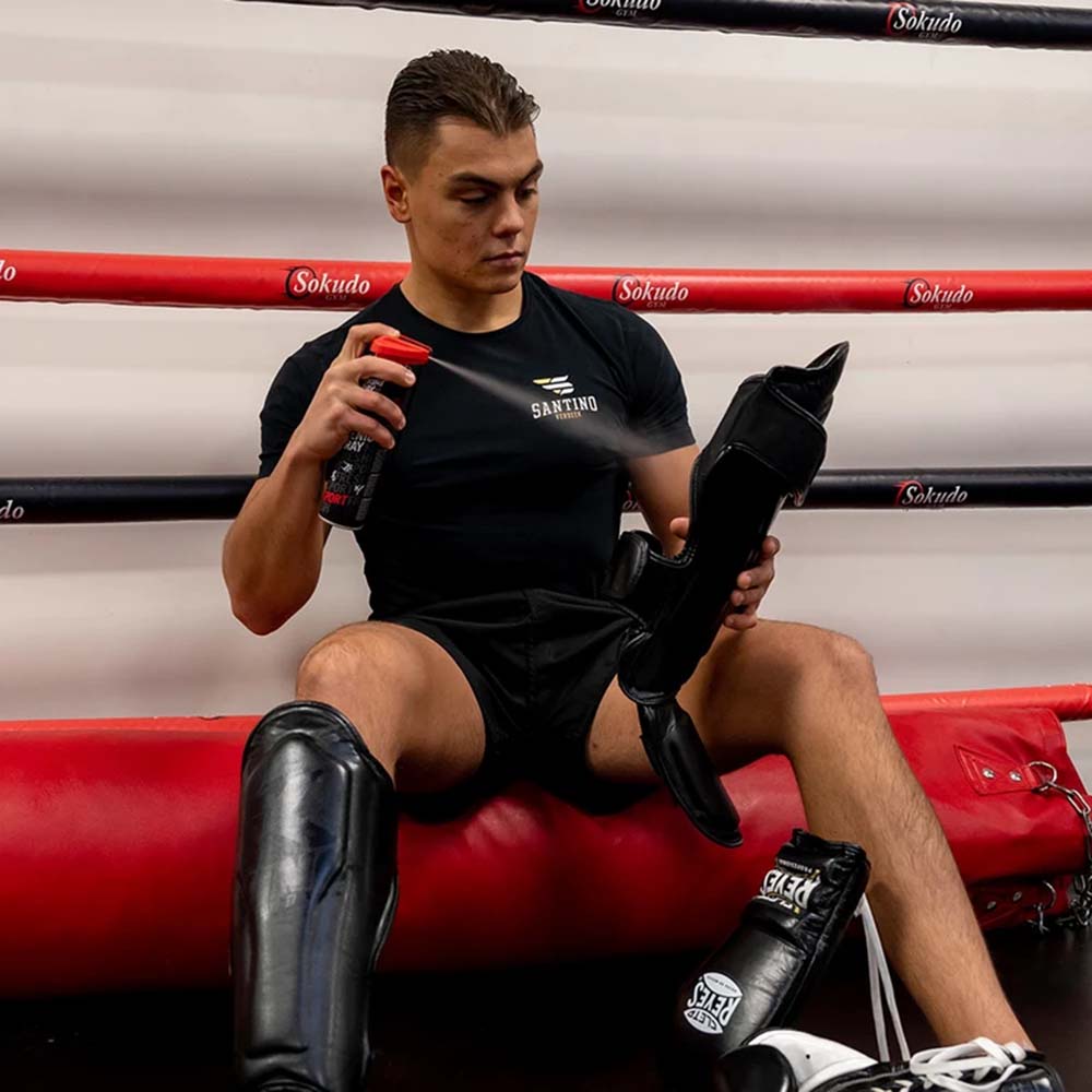 Athlete with Sukkiri Spray and a shin guard in a boxing ring