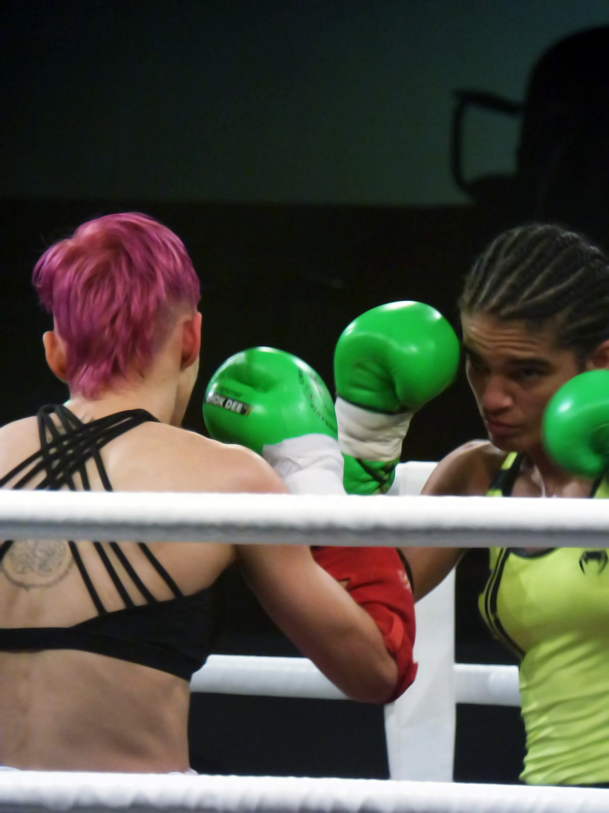 Anissa Meksen rechts met groene bokshandschoenen tegenover een tegenstander in de ring
