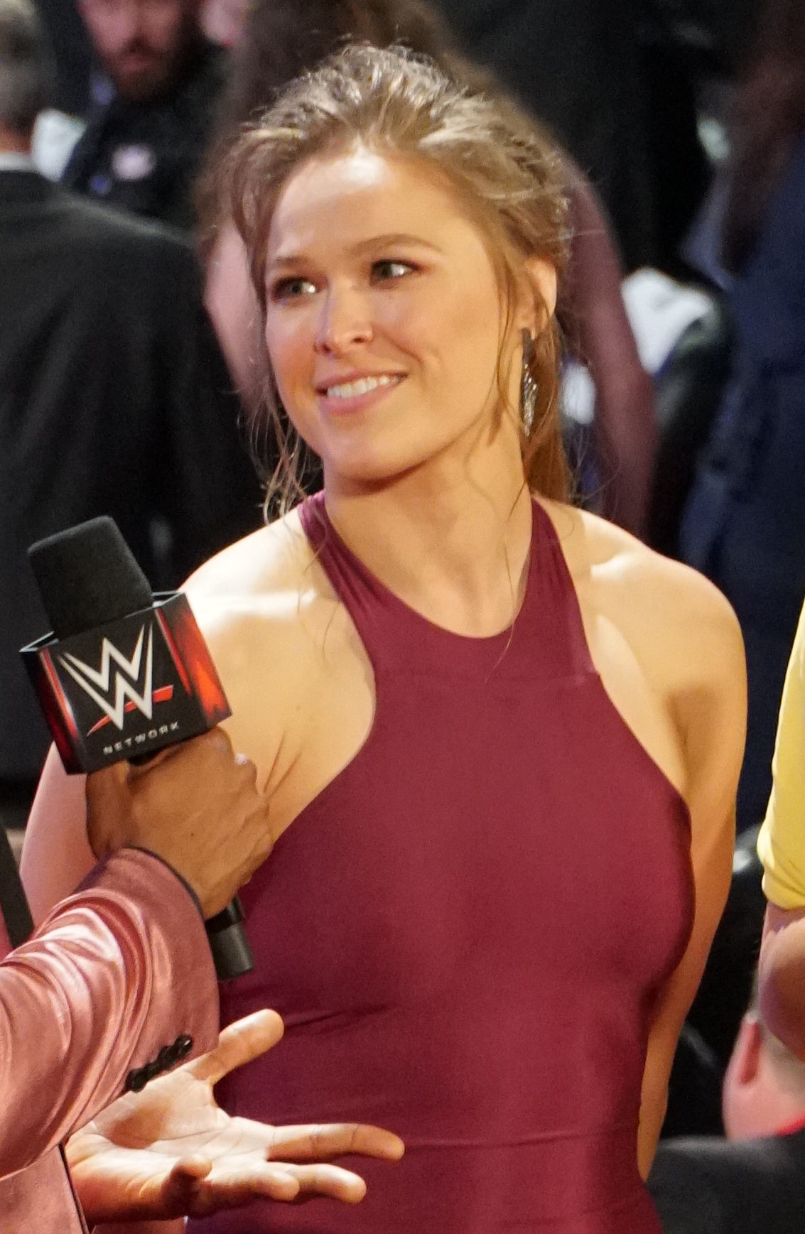 Ronda Rousey in een rode jurk tijdens een interview bij het WWE Hall of Fame-evenement