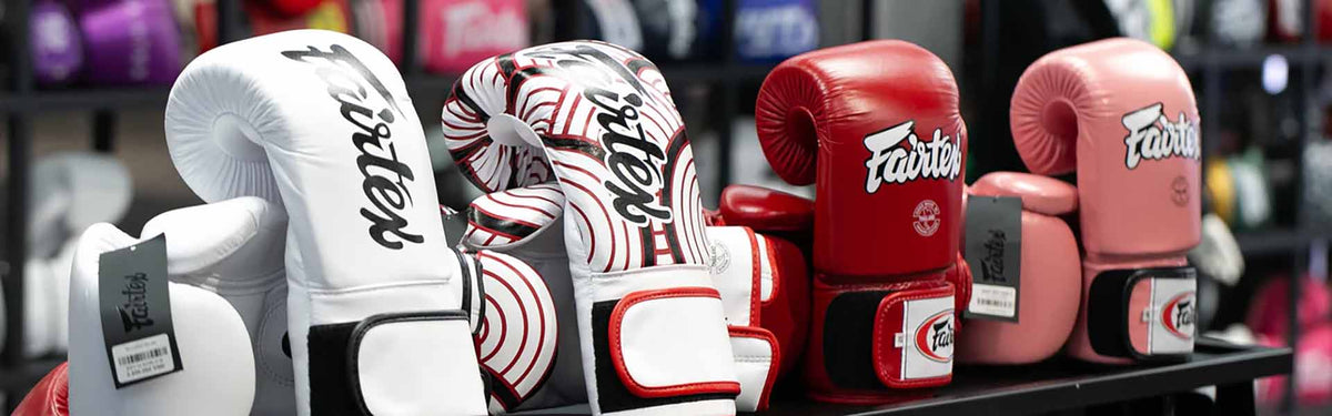Varios guantes de boxeo Fairtex en una estantería de tienda