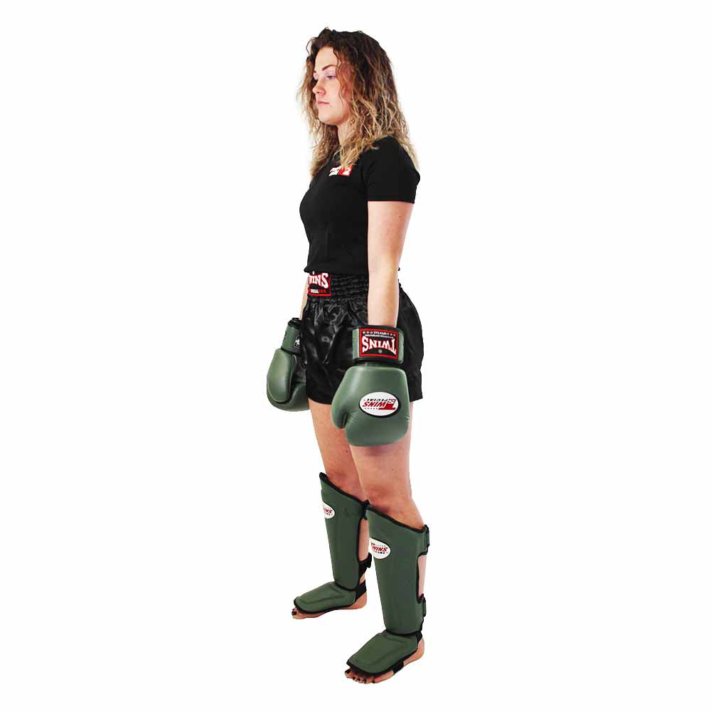 Sporter met groene Twins Special-handschoenen en scheenbeschermers.